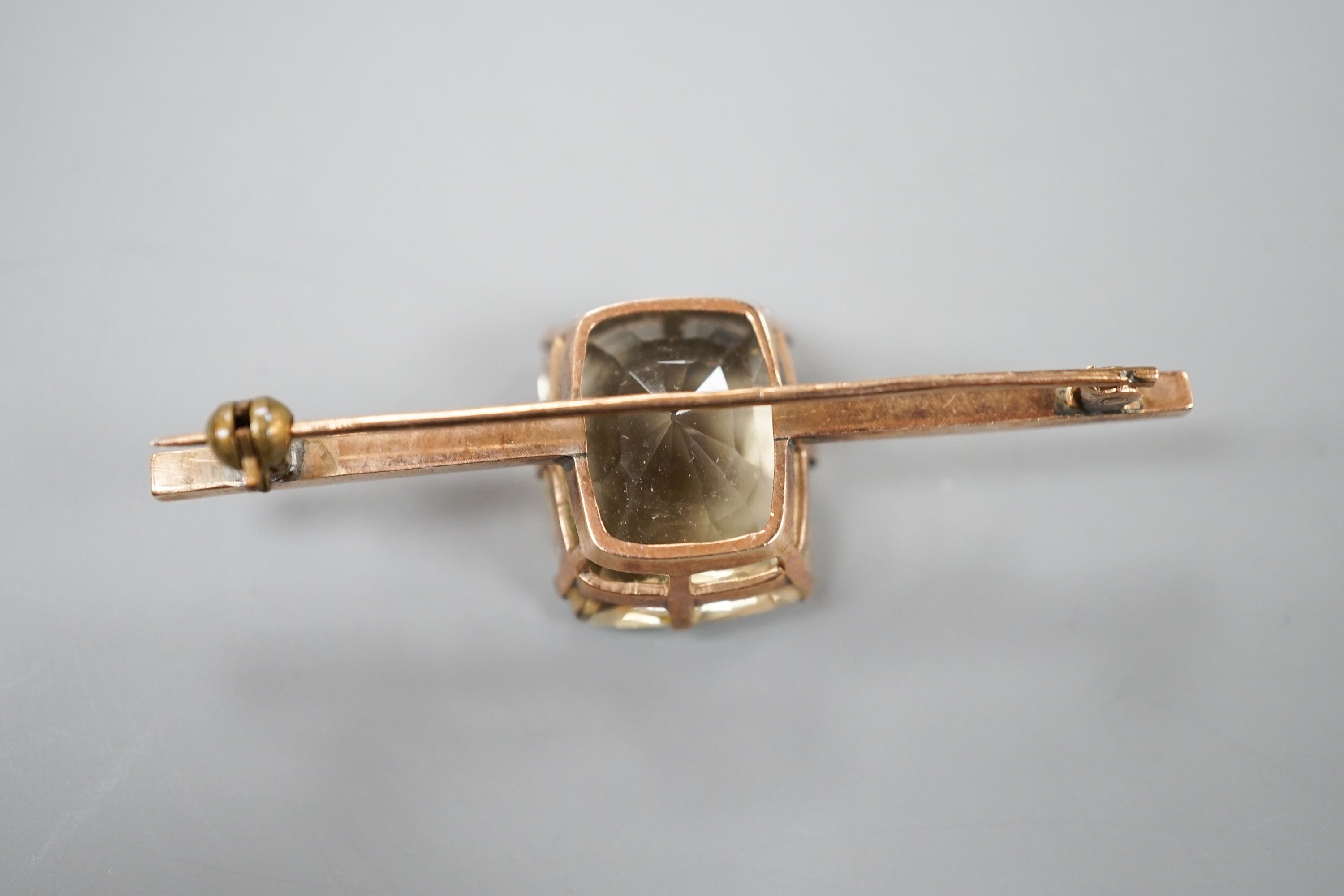 A yellow metal and citrine set bar brooch, 61mm, gross weight 11.9 grams.